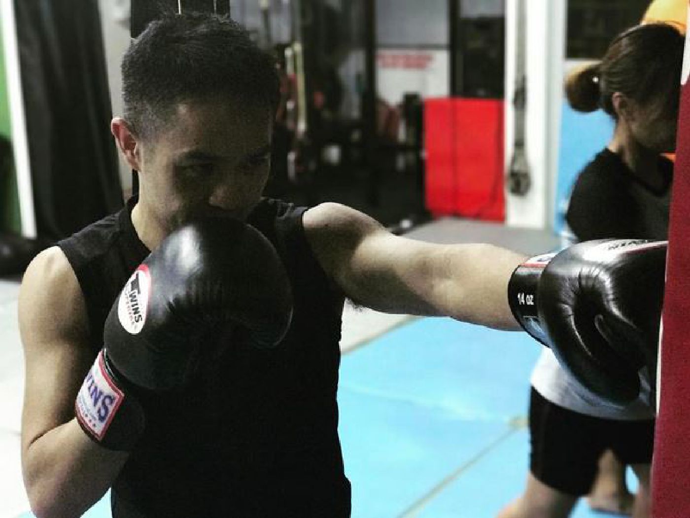 Muay Thai Singapore West student doing bagwork with focus