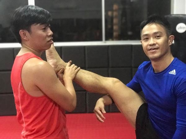 Muay Thai Singapore West students doing stretching exercises